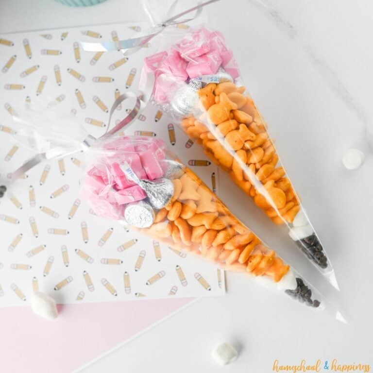 Two pencil treat bags filled with candy and crackers.