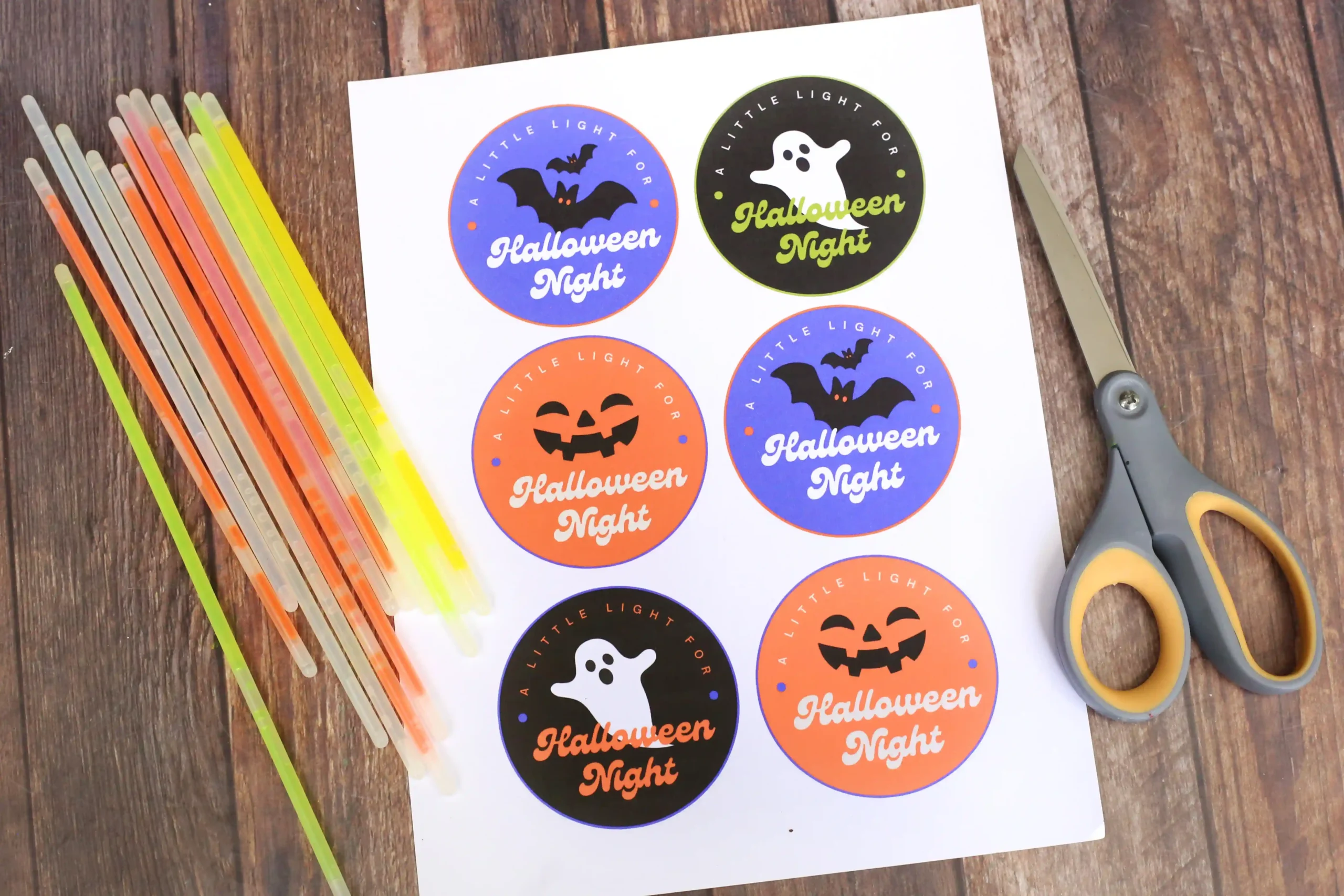 supplies for the printable halloween tags: printable tags, scissors, and glow sticks