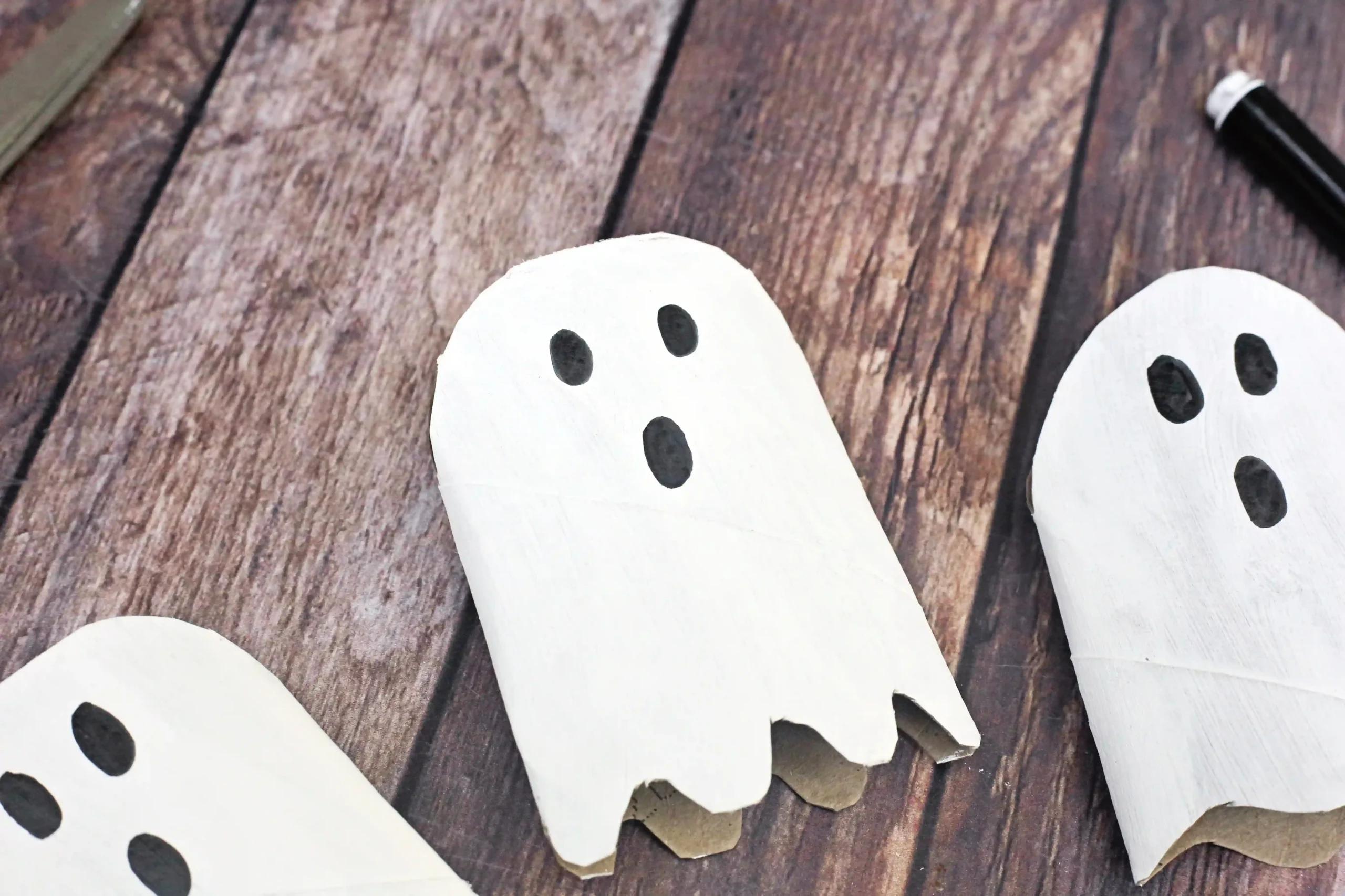 toilet paper rolls cut, painted, and decorated to look like ghosts