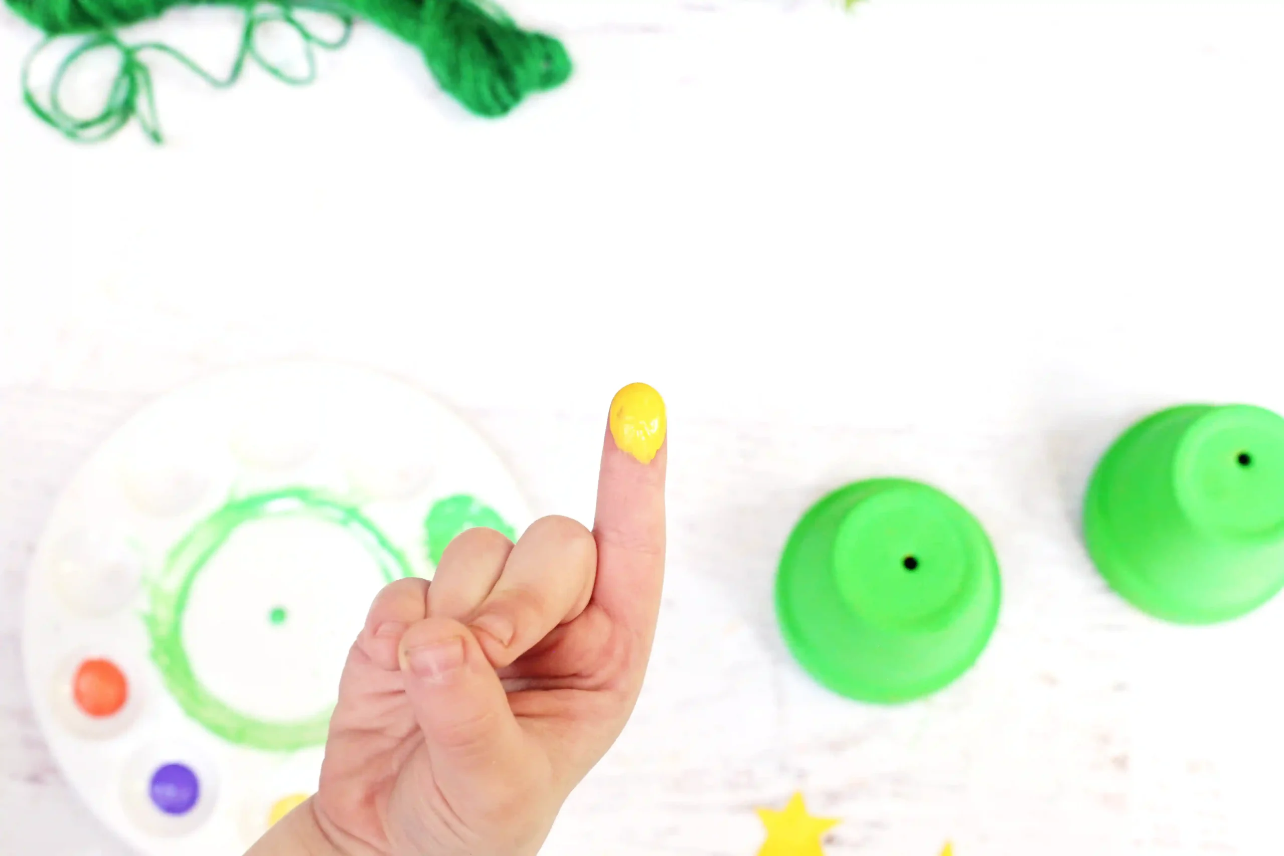 a child's finger with yellow paint on it
