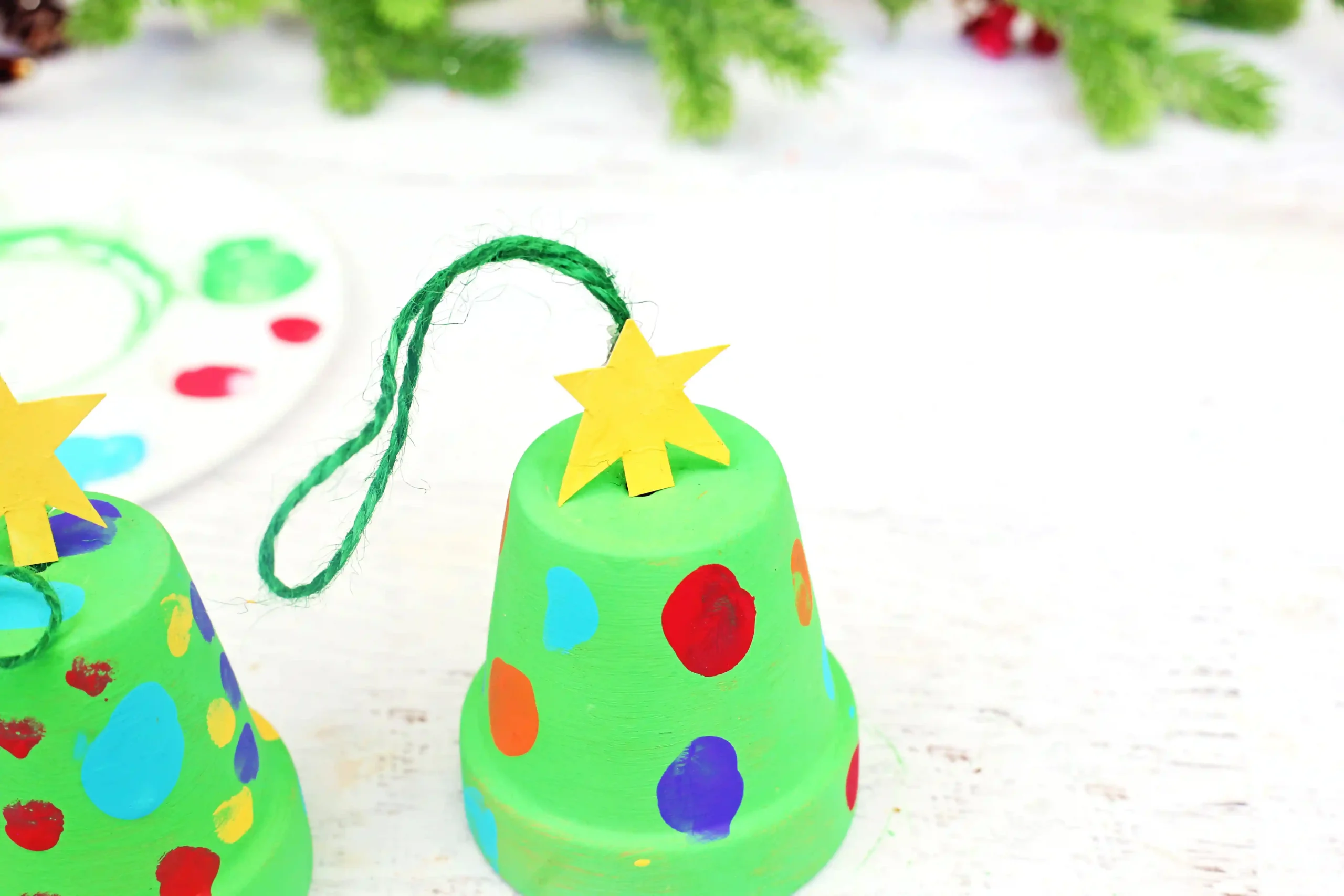 a clay pot painted green with fingerprint "lights" and a cardboard star