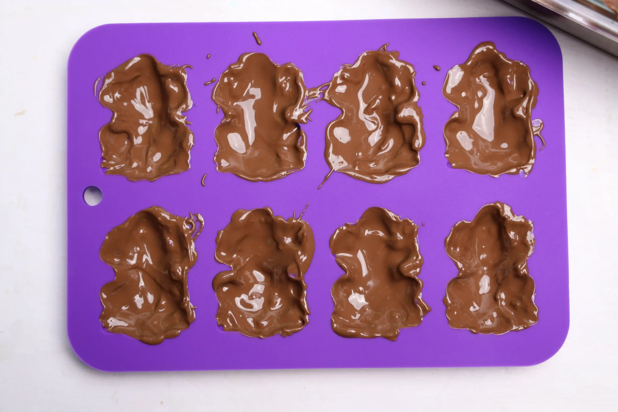 a purple frog mold with chocolate in it