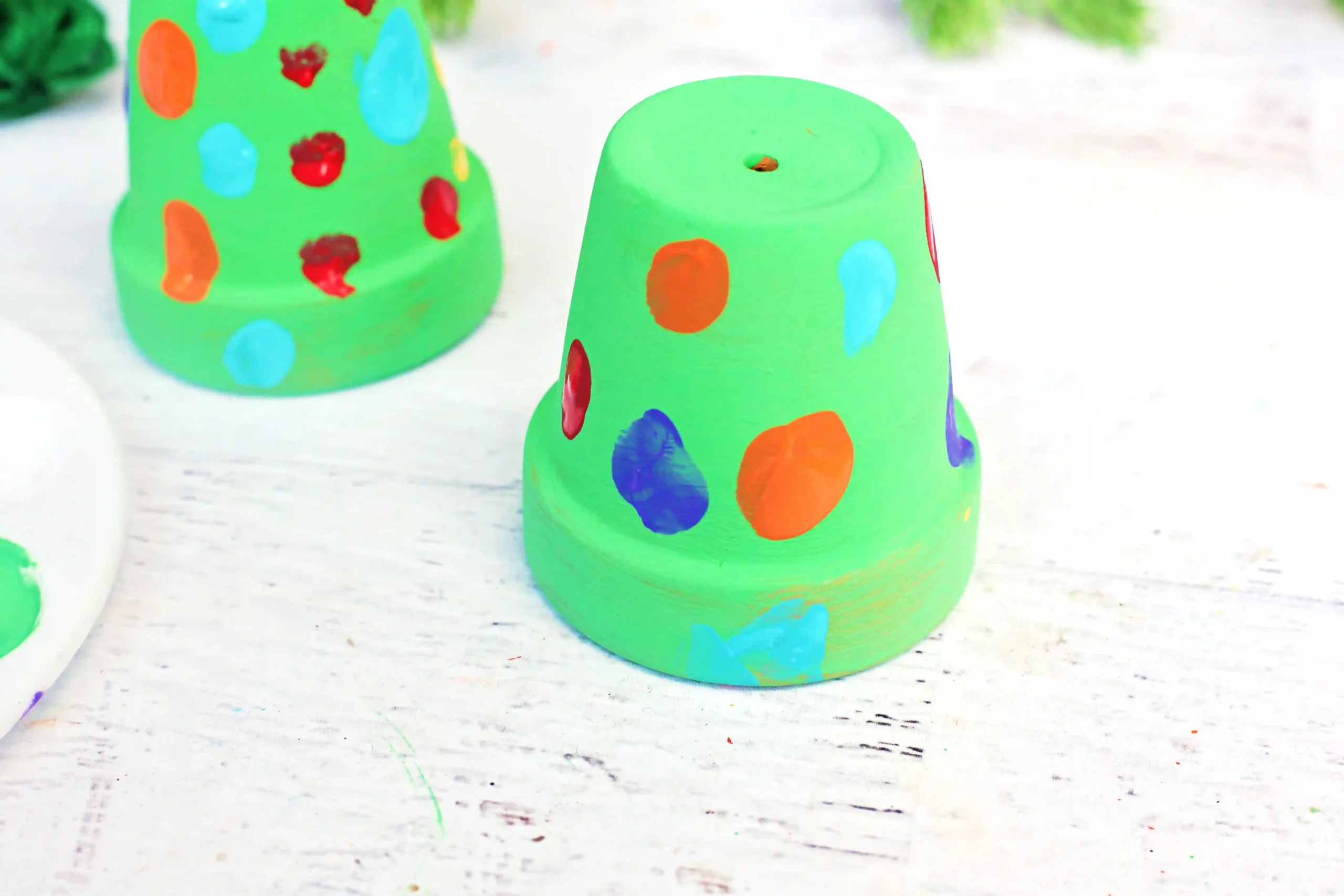 a clay pot painted green with fingerprint "lights"