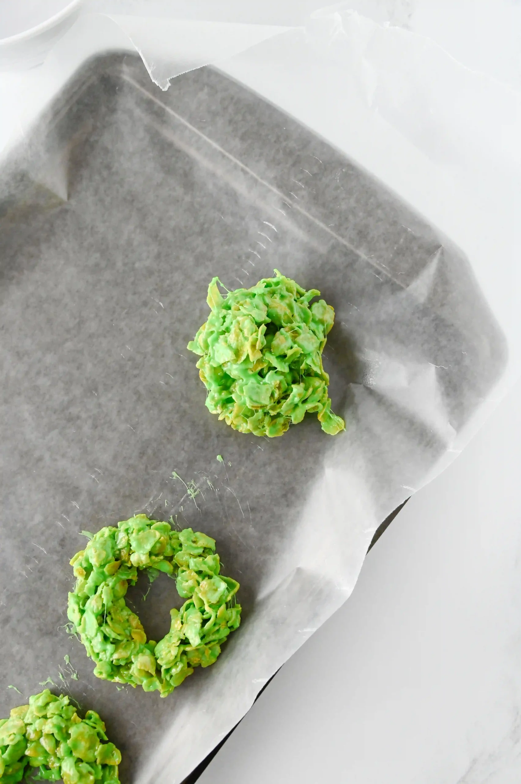 balls of green cornflake mixture on parchment paper